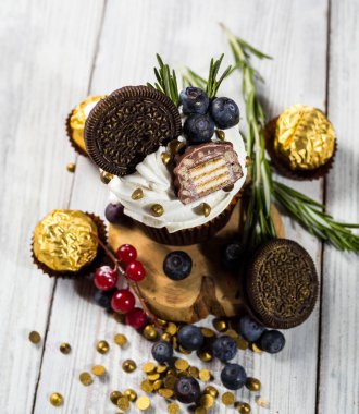 Çikolatalı kek. Cupcakes. Meyveler, meyve, çilek ile cupcakes. En çok view.colorful kek, lezzetli kek, renkli krema, şeker, ahşap arka plan üzerinde yaz meyveleri ile cupcakes, tatlı kavramı, kapatmak