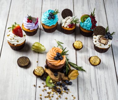 Çikolatalı kek. Cupcakes. Meyveler, meyve, çilek ile cupcakes. En çok view.colorful kek, lezzetli kek, renkli krema, şeker, ahşap arka plan üzerinde yaz meyveleri ile cupcakes, tatlı kavramı, kapatmak