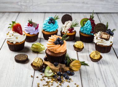 Çikolatalı kek. Cupcakes. Meyveler, meyve, çilek ile cupcakes. En çok view.colorful kek, lezzetli kek, renkli krema, şeker, ahşap arka plan üzerinde yaz meyveleri ile cupcakes, tatlı kavramı, kapatmak