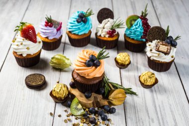 Çikolatalı kek. Cupcakes. Meyveler, meyve, çilek ile cupcakes. En çok view.colorful kek, lezzetli kek, renkli krema, şeker, ahşap arka plan üzerinde yaz meyveleri ile cupcakes, tatlı kavramı, kapatmak