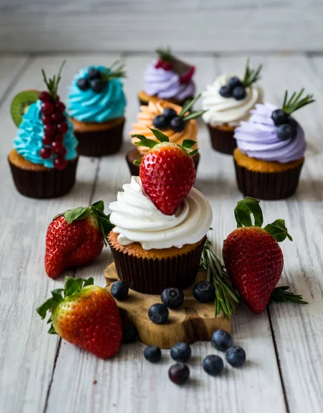 Chocolate cupcakes. Cupcakes. Cupcakes with berries,fruit,strawberries. Top view.colorful cupcake,tasty cake,colorful cream,cupcakes with summer berries on wooden background,close up,dessert concept