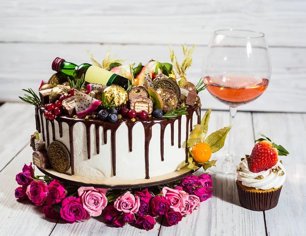 Шоколадные кексы и торт. Кексы с ягодами, фруктами, клубникой. Топ view.colorful кекс, вкусный торт, крем, конфеты, деревянный фон, закрыть, десерт концепции, День рождения торт с вином, Рим — стоковое фото