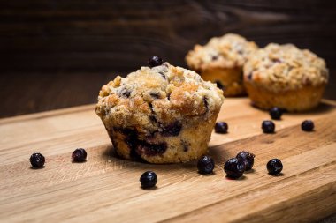 taze pişmiş blueberry muffins bir yulaf ile Tepesi üzerinde doğal ahşap masa, ev yapımı yaban mersinli kek, lezzetli kek yaban mersini ile harap, kavram çöl