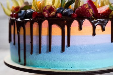 Renkli katmanları ile çikolata cupcakes meyve, çilek ve şeker ile dekore edilmiştir. View.Colorful lezzetli kek, renkli krem, ahşap arka plan top, tatlı kavramı, doğum günü pastası, kapatmak 