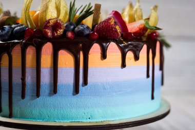 Renkli katmanları ile çikolata cupcakes meyve, çilek ve şeker ile dekore edilmiştir. View.Colorful lezzetli kek, renkli krem, ahşap arka plan top, tatlı kavramı, doğum günü pastası, kapatmak 