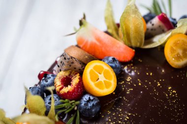 Renkli katmanları ile çikolata cupcakes meyve, çilek ve şeker ile dekore edilmiştir. View.Colorful lezzetli kek, renkli krem, ahşap arka plan top, tatlı kavramı, doğum günü pastası, kapatmak 