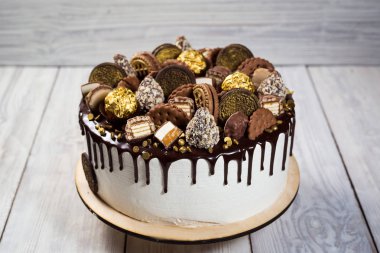 Renkli katmanları ile çikolata cupcakes meyve, çilek ve şeker ile dekore edilmiştir. View.Colorful lezzetli kek, renkli krem, ahşap arka plan top, tatlı kavramı, doğum günü pastası, kapatmak 