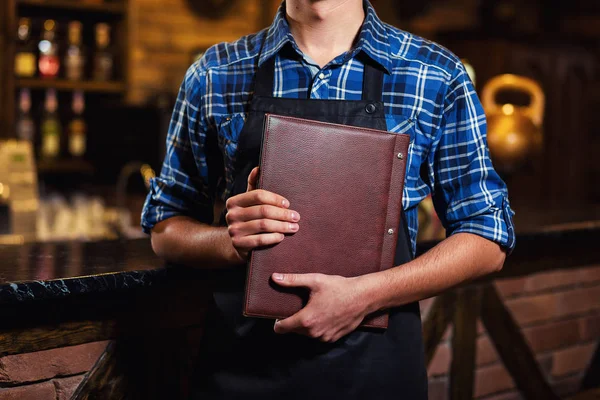 Barman en el trabajo en el pub, Retrato de barman alegre trabajador de pie, Camarero dando menús, Un pub.Bar.Restaurant.Classic.Evening.Restaurante europeo.Bar europeo.Restaurante americano.Bar americano . — Foto de Stock