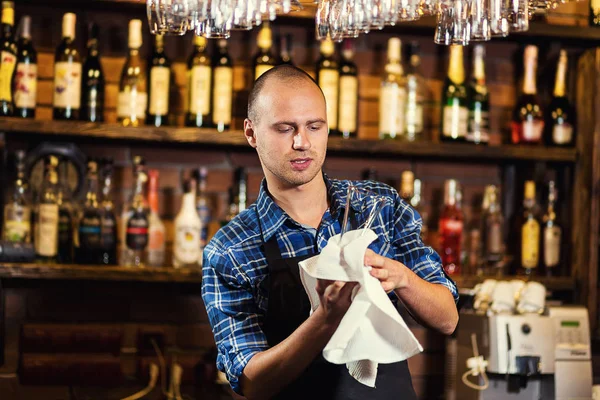 Barman at work in pub,Portrait of cheerful barman worker standing,Waiter giving menus,A pub.Bar.Restaurant.Classic.Evening.European restaurant.European bar.American restaurant.American bar.