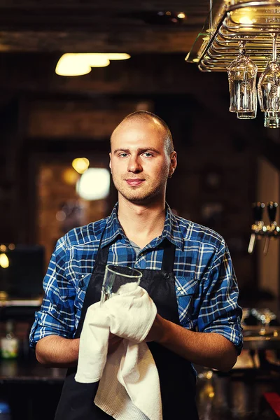 Barman at work in pub,Portrait of cheerful barman worker standing,Waiter giving menus,A pub.Bar.Restaurant.Classic.Evening.European restaurant.European bar.American restaurant.American bar.