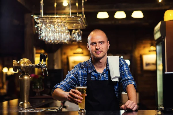 Bartender pouring the fresh beer in pub,barman hand at beer tap pouring a draught lager beer,beer from the tap,Filling glass with beer,fresh beer,pub.Bar.Restaurant.European bar.American bar.