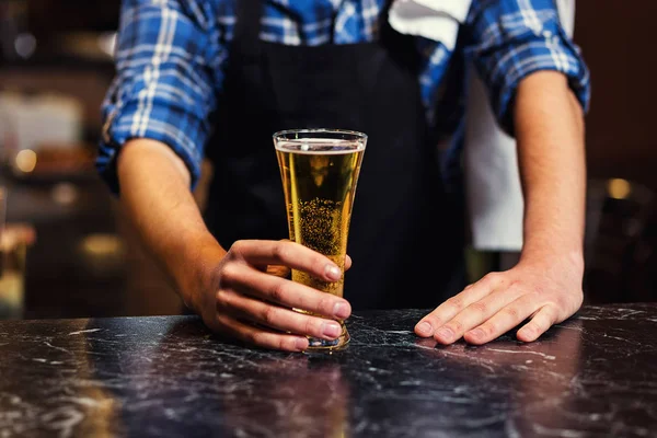 Barkeeper gießt das frische Bier in der Kneipe, Barmann Hand an Bierhahn gießt ein gezapftes Lagerbier, Bier aus dem Zapfhahn, Füllglas mit Bier, frisches Bier, pub.bar.restaurant.european bar.american bar. — Stockfoto