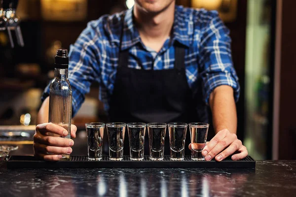 Barman en el trabajo, Barman vertiendo espíritu duro en vasos en detalle, Bartender está vertiendo tequila en vidrio, preparando cócteles, concepto sobre servicio y bebidas — Foto de Stock