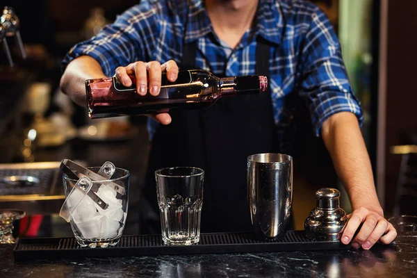 Бармен за работой, бармен наливает крепкий дух в бокалы в деталях, бармен наливает текилу в бокал, готовит коктейли, концепцию обслуживания и напитков — стоковое фото