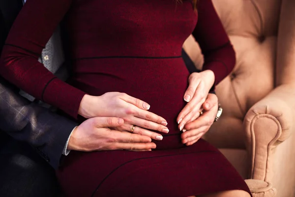 Foto de vientre de mujer embarazada. Las manos abrazando la barriga embarazada. Acercamiento de manos humanas sosteniendo la barriga embarazada. La mujer embarazada abraza su vientre. Embarazo. Concepto de embarazo —  Fotos de Stock