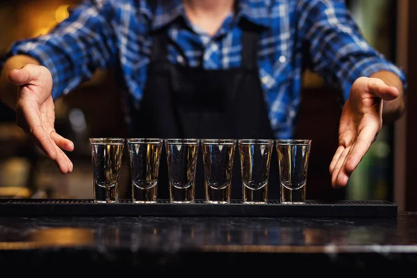 Barman en el trabajo, Barman vertiendo espíritu duro en los vasos en detalle, Bartender está vertiendo tequila en el vidrio, preparando cócteles, concepto de servicio — Foto de Stock