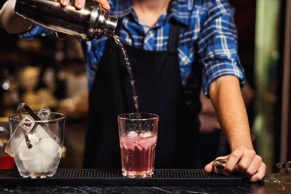 Barmann bei der Arbeit, Barmann gießt harten Geist ins Glas, Barkeeper gießt Tequila ins Glas, bereitet Cocktails vor, Servicekonzept — Stockfoto