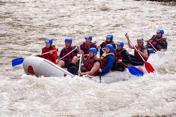 Carpathians, Ukraine - May 01,2015.Rafting team splashing the waves, rafting extreme and fun sport.Group of people with guide whitewater rafting and rowing on river,rafting boat,extreme sport — Stock Photo, Image