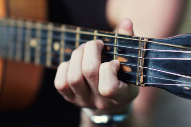 Pratik gitar çalmak. Yakışıklı genç adam gitar, Closeup bulanık erkek eller iskambil gitar, müzik konsepti