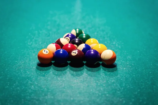 Billiard balls in a green pool table, game. Table for billiards with balls.Fragment of the pool billiard game in process. American pool billiard. Pool billiard game. Billiard sport concept