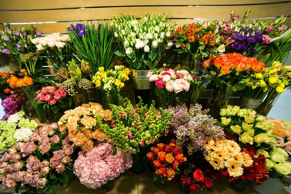 Rosas coloridas e outras flores na entrada da loja de flores, Buquê decorar na frente da loja de flores, Muitas flores no mercado, flores no mercado dos agricultores — Fotografia de Stock
