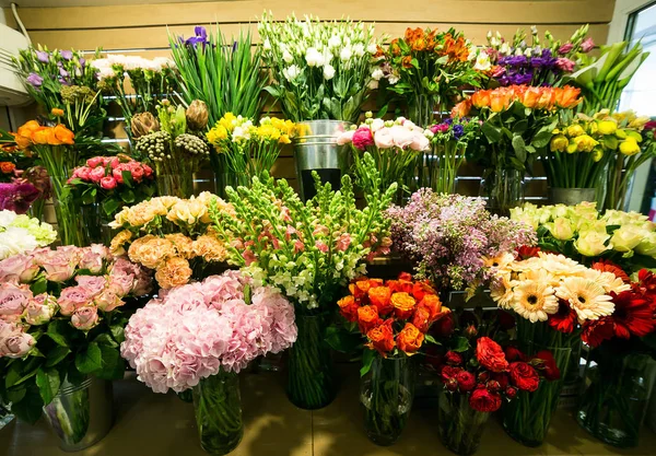 Rosas coloridas e outras flores na entrada da loja de flores, Buquê decorar na frente da loja de flores, Muitas flores no mercado, flores no mercado dos agricultores — Fotografia de Stock