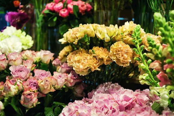 Rosas coloridas e outras flores na entrada da loja de flores, Buquê decorar na frente da loja de flores, Muitas flores no mercado, flores no mercado dos agricultores — Fotografia de Stock