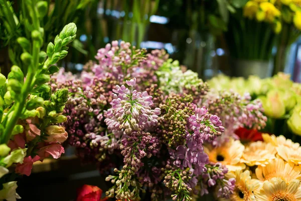 Buquê de lilás, rosas coloridas e outras flores na entrada da loja de flores, Buquê decorar na frente da loja de flores, Muitas flores no mercado, flores no mercado dos agricultores — Fotografia de Stock