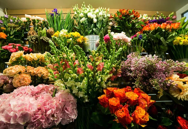 Rosas coloridas e outras flores na entrada da loja de flores, Buquê decorar na frente da loja de flores, Muitas flores no mercado, flores no mercado dos agricultores — Fotografia de Stock