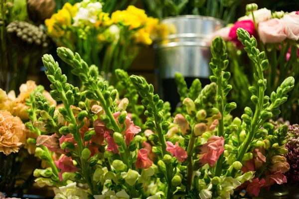 Rosas coloridas e outras flores na entrada da loja de flores, Buquê decorar na frente da loja de flores, Muitas flores no mercado, flores no mercado dos agricultores — Fotografia de Stock