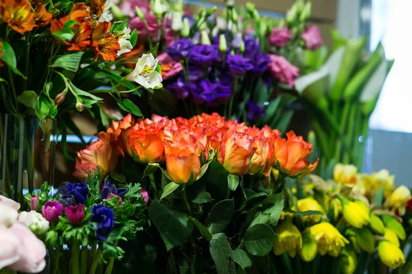 Bukett med rosor, färgglada rosor och andra blommor på posten till blomsteraffär, bukett dekorera framför blomsteraffär, många blommor i marknaden, blommor på bondens marknad — Stockfoto