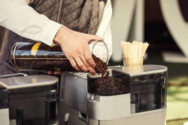 Barista kahve çekirdekleri bir kahve makinesi dökülen, barista yakın lezzetli kahve hazırlama eller yukarı. Kafe Restoran Cafe hazırlık concept.coffee maker Makina içinde