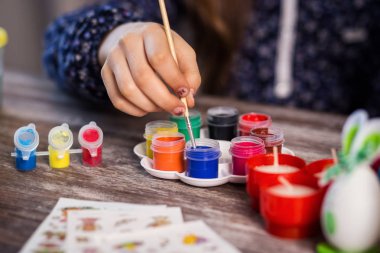 evde eastertime için yumurta boyama. Mutlu Paskalyalar! Bir anne ve kızı Paskalya yumurta boyama. Mutlu aile Easter.decorating Paskalya yumurtaları, çocuk eller için hazırlanıyor tutun bir fırça ve boya