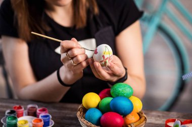 evde eastertime için yumurta boyama. Mutlu Paskalyalar! Bir anne, Paskalya yumurta boyama kız. Mutlu aile Easter.decorating Paskalya yumurtaları, kadın eller için hazırlanıyor tutun bir fırça ve boya