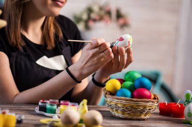 evde eastertime için yumurta boyama. Mutlu Paskalyalar! Bir anne, Paskalya yumurta boyama kız. Mutlu aile Easter.decorating Paskalya yumurtaları, kadın eller için hazırlanıyor tutun bir fırça ve boya