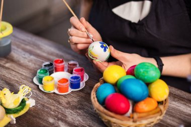 evde eastertime için yumurta boyama. Mutlu Paskalyalar! Bir anne, Paskalya yumurta boyama kız. Mutlu aile Easter.decorating Paskalya yumurtaları, kadın eller için hazırlanıyor tutun bir fırça ve boya