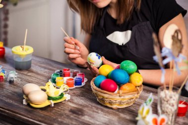 evde eastertime için yumurta boyama. Mutlu Paskalyalar! Bir anne, Paskalya yumurta boyama kız. Mutlu aile Easter.decorating Paskalya yumurtaları, kadın eller için hazırlanıyor tutun bir fırça ve boya