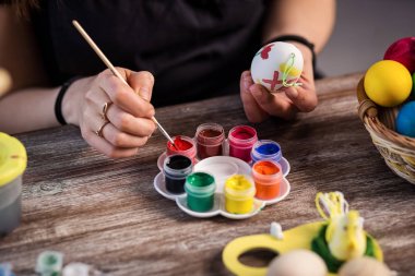 evde eastertime için yumurta boyama. Mutlu Paskalyalar! Bir anne, Paskalya yumurta boyama kız. Mutlu aile Easter.decorating Paskalya yumurtaları, kadın eller için hazırlanıyor tutun bir fırça ve boya