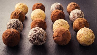 Çikolata, kakao tozu ile trüf çikolata şekerleme. Çikolata şekerleme koleksiyonu. Toz kakao, Hindistan cevizi ve kıyılmış fındık tatlısı tabakta çeşitli çikolata truffles.