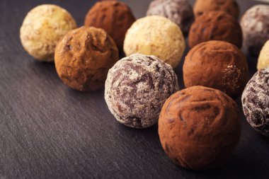 Çikolata, kakao tozu ile trüf çikolata şekerleme. Çikolata şekerleme koleksiyonu. Toz kakao, Hindistan cevizi ve kıyılmış fındık tatlısı tabakta çeşitli çikolata truffles.