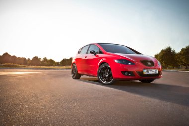 Vinnitsa, Ukrayna-Temmuz 26,2012.The Seat Leon tarafından İspanyol araba yapımı bir küçük aile spor hatchback olduğunu. Seat Leon konsept otomobil. Açık arabanın ön, logo Seat.Car yolda araba hareket, kırmızı araba