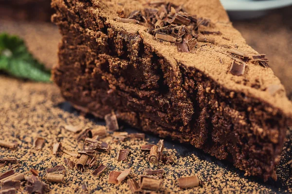 Шоколадный торт с конфетками, шоколадный торт с кусочком и лезвием на сером фоне, крупный план, темный шоколадный торт, вкусный веганский шоколадный торт, вкусный шоколадный торт на деревянном фоне — стоковое фото