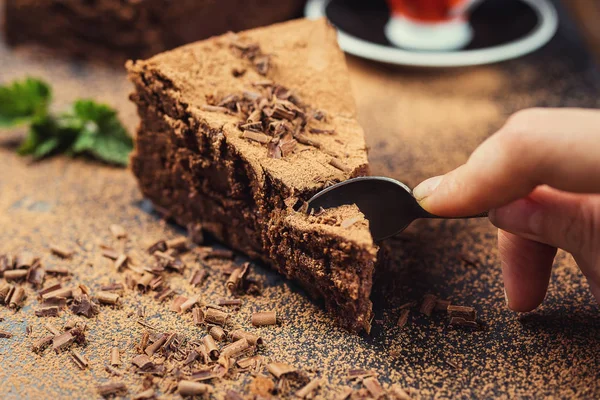 Шоколадный торт с конфетками, шоколадный торт с кусочком и лезвием на сером фоне, крупный план, темный шоколадный торт, вкусный веганский шоколадный торт, вкусный шоколадный торт на деревянном фоне — стоковое фото