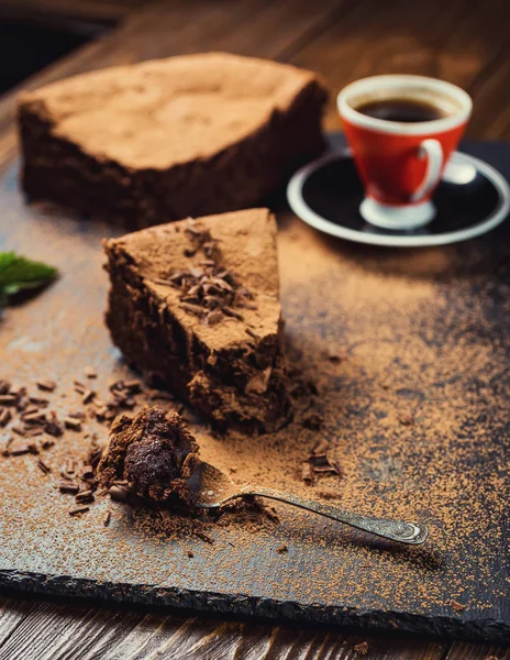 Gâteau au chocolat avec des bonbons, gâteau au chocolat avec un morceau coupé et une lame sur fond gris, gros plan, gâteau au chocolat noir, Délicieux gâteau au chocolat végétalien, Gâteau au chocolat savoureux sur fond en bois — Photo