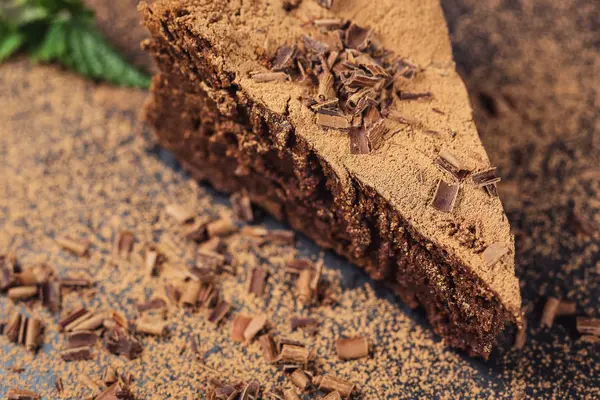 Шоколадный торт с конфетками и чашкой кофе, шоколадный торт с нарезанным кусочком и лезвием на сером фоне, крупный план, темный шоколадный торт, веганский шоколадный торт, вкусный шоколадный торт на деревянном фоне — стоковое фото
