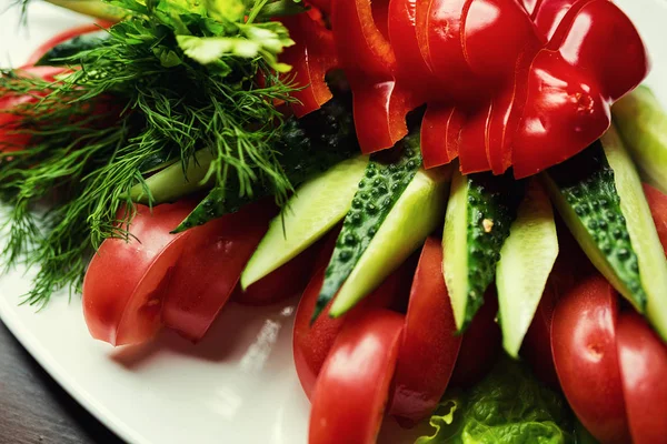 Szeletelt zöldség a tányéron. Tál vegyes friss zöldségek. Egészséges vegetáriánus saláta paradicsom, az uborka, a paprika és a Zöldek. Egészséges étkezési szokások, diéta élelmiszer — Stock Fotó