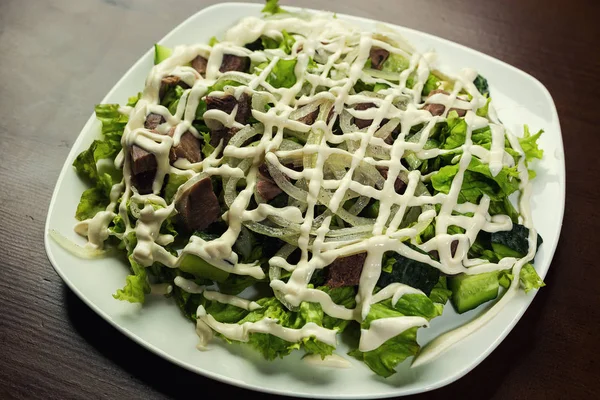 Salada com carne, cogumelos e pepino e azeitonas, salada saborosa em restaurador — Fotografia de Stock