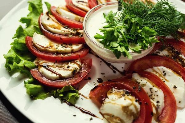 Deliziosa insalata caprese con pomodori maturi e mozzarella con foglie di basilico fresche. Cucina italiana.Insalata italiana, insalata Caprese Piatto di sana insalata Caprese classica — Foto Stock