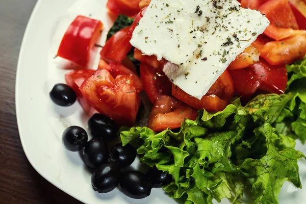 Grecka Sałatka ze świeżych warzyw, sera feta i oliwki czarne, Świeża sałatka grecka w misce, widok z góry — Zdjęcie stockowe