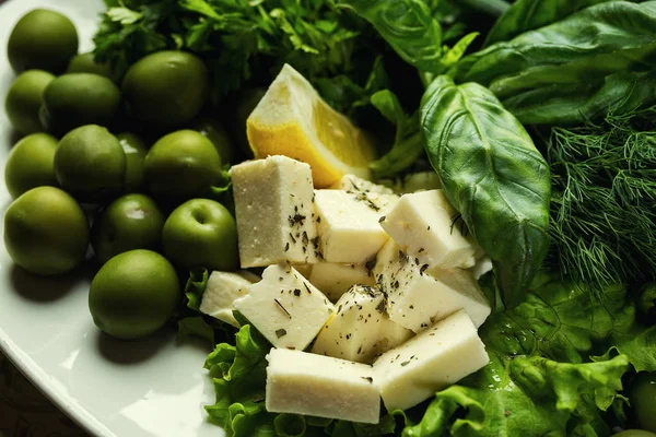 Olive, brynza e verdure su un piatto, Insalata fresca con bryndza, olive, piatto di formaggio morbido (feta e bryndza), Olive verdi nella ciotola — Foto Stock